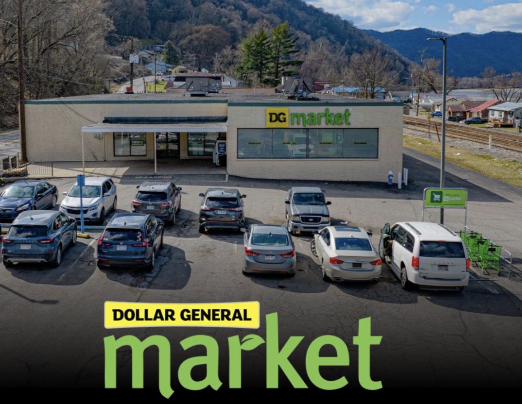 Dollar General Market retail store triple net (NNN) investment property with dedicated parking in a small-town commercial area.